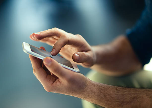 Male hands typing on smartphone.